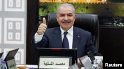 Palestinian Prime Minister Mohammad Shtayyeh gestures, as he convenes cabinet meeting, in Ramallah in the Israeli-occupied West Bank, Feb. 26, 2024.