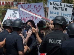 Manifestantes confrontan a la policía en Los Angeles, California, el 30 de mayo de 2020, durante una protesta por la muerte de George Floyd, un afroestadounidense que murió tras ser arrestado por la policía en Minnneapolis, Minnesota, el 25 de mayo.