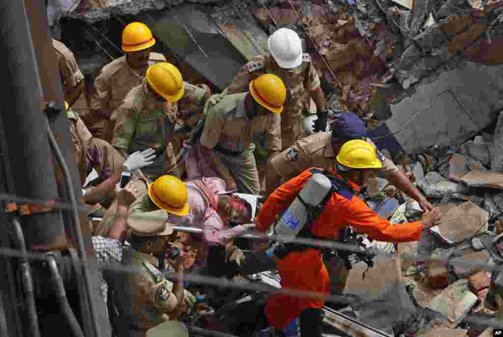 Fire officials rescue an injured person from a collapsed building in Secunderabad outside Hyderabad, India, July 8, 2013.
