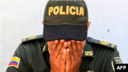 Un oficial de policía se muestra consternado durante una vigilia en honor a los policías asesinados en un ataque en Barranquilla, Colombia, el 28 de enero de 2018© AFP