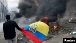 Un manifestante lleva la bandera ecuatoriana durante una protesta contra el presidente de Ecuador Lenín Moreno.