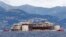 Буксир тянет лайнер Costa Concordia в порт Генуи в Италии, где он будет разобран на металлолом. 27 июля 2014 г.