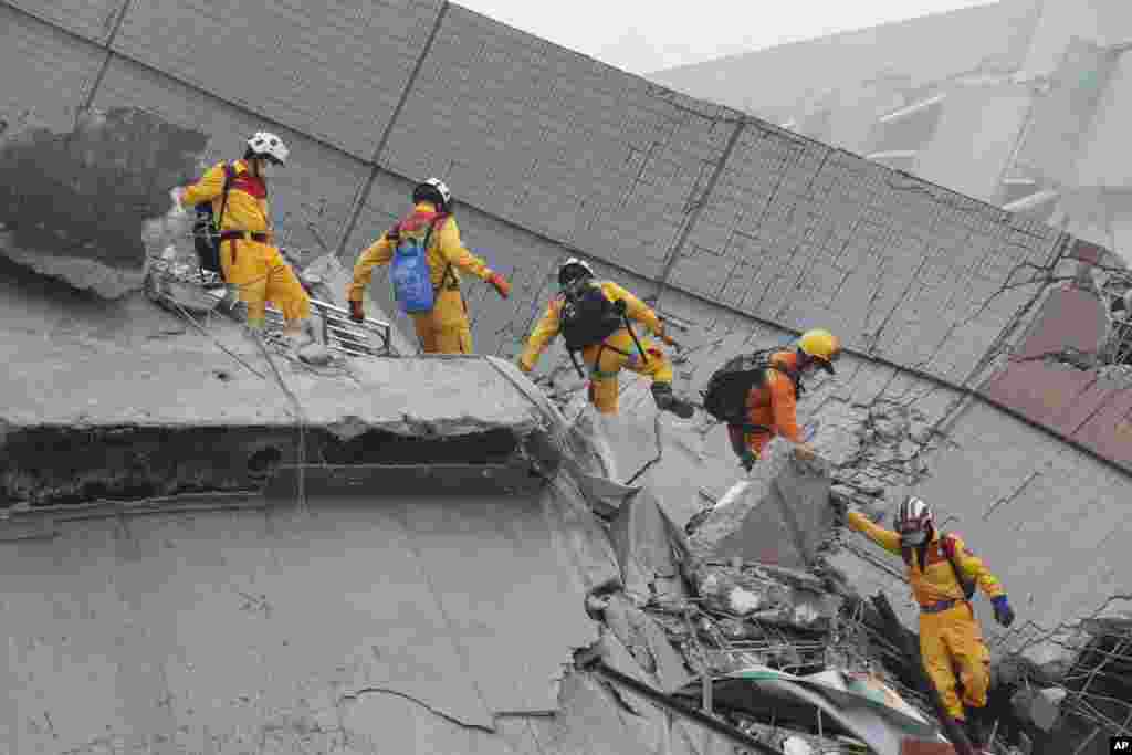 Rescue workers search a collapsed building from an early morning earthquake in Tainan, Taiwan, Saturday, Feb. 6, 2016. 