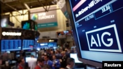 FILE - The American International Group Inc. (AIG) stock ticker is seen on a monitor as traders work on the floor of the New York Stock Exchange after the opening bell Feb. 11, 2013. 