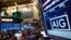 FILE - The American International Group Inc. (AIG) stock ticker is seen on a monitor as traders work on the floor of the New York Stock Exchange after the opening bell Feb. 11, 2013. 