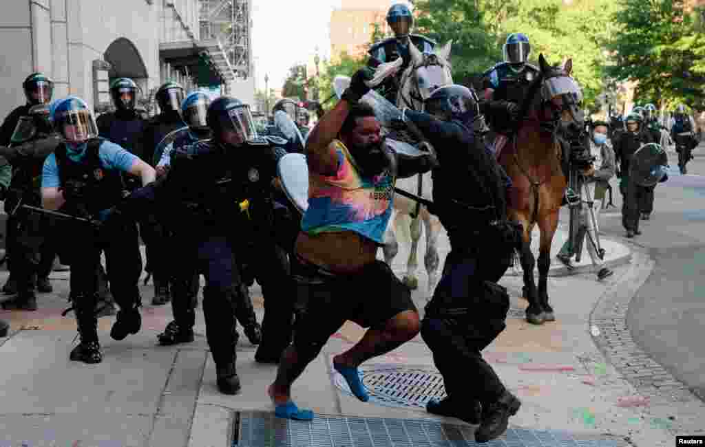 Riot police chase a man as they rush protesters to clear Lafayette Park and the area around it across from the White House for President Donald Trump to be able to walk through for a photo opportunity in front of St. John&#39;s Episcopal Church, June 1, 2020.