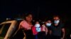 Para migran dari Honduras menunggu di truk milik patroli perbatasan setelah menyerahkan diri ketika menyeberangi perbatasan Meksiko-AS di La Joya, Texas, Senin, 17 Mei 2021. 
