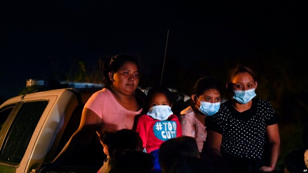Para migran dari Honduras menunggu di truk milik patroli perbatasan setelah menyerahkan diri ketika menyeberangi perbatasan Meksiko-AS di La Joya, Texas, Senin, 17 Mei 2021. 