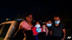 FILE - Migrants from Honduras wait in a Border Patrol truck after turning themselves in upon crossing the U.S.-Mexico border. The U.S. government continues to report large numbers of migrants crossing the border, with an increase in adult crossers. 