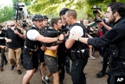 Uniformed U.S. Secret Service police detain a protester in Lafayette Park across from the White House as demonstrators protest the death of George Floyd, a black man who died in police custody in Minneapolis.