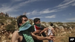 Palestinians throw stones at Israeli troops during clashes in the West Bank village of Iraq Burin, near Nablus, 15 May 2010 (file photo). Residents of the village said they are trying to prevent Jewish settlers from bathing in a water cistern Palestinian