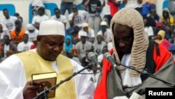 Le président de la Gambie, Adama Barrow, tient le Coran lors de la cérémonie d'investiture au stade de l'indépendance, à Bakau, Gambie, 18 février 2017. 