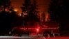 Sebuah mobil pemadan kebakaran terlihat di tengah kebakaran Caldor yang melahap deretan pepohonan di Christmas Valley, dekat South Lake Tahoe, California, AS, 31 Agustus 2021. (REUTERS/Brittany Hosea-Small)