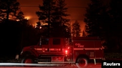 Sebuah mobil pemadan kebakaran terlihat di tengah kebakaran Caldor yang melahap deretan pepohonan di Christmas Valley, dekat South Lake Tahoe, California, AS, 31 Agustus 2021. (REUTERS/Brittany Hosea-Small)