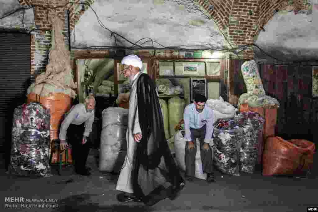 دو کاسب به احترام مرد روحانی نیم خیز می شوند. خبرگزاری مهر عکسهایی با عنوان &quot;زندگی روزمره و محیط پیرامون در شهر تبریز:&quot; منتشر کرده است. عکس: مجید حقدوست، مهر