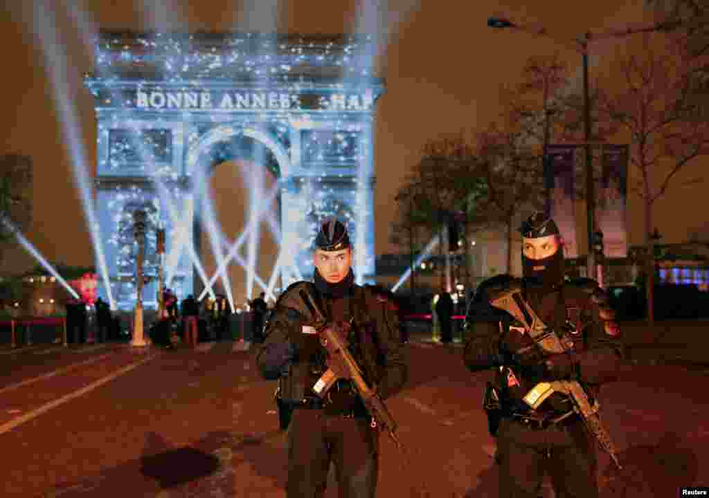 Policemen secure the Champs Elysees Avenue as revelers gather during New Year celebrations in Paris, France, Dec. 31, 2016.