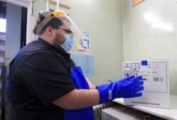 A pharmacy technician from Croydon Health Services takes a delivery of the first batch of COVID-19 vaccinations at Croydon University Hospital in Croydon, Britain, Dec. 5, 2020. (Gareth Fuller/Pool via Reuters)