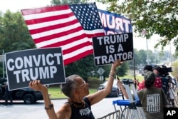 Laurie Arbeiter dari New York City berada di antara para pendukung Trump di depan Penjara Fulton County di Atlanta, Kamis, 24 Agustus 2023. (AP/Ben Gray)