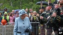 Queen Elizabeth II inspects the guard of honor before entering Balmoral Castle, Scotland, at the start of her annual holiday, Aug. 6, 2019.