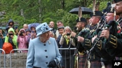 FILE - Queen Elizabeth II inspects the guard of honor before entering Balmoral Castle, Scotland, at the start of her annual holiday, Aug. 6, 2019.