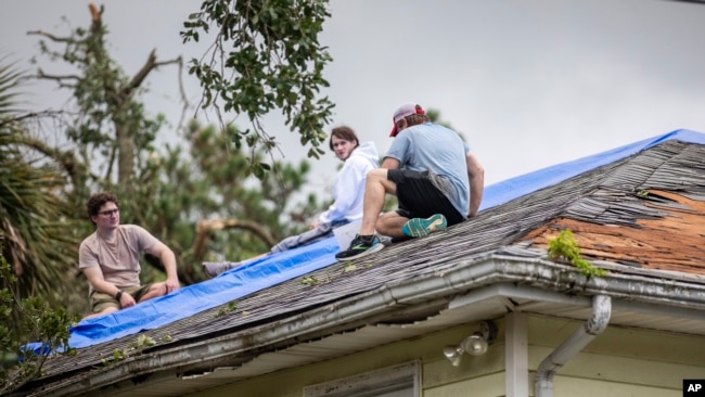 Residentes reparan un tejado después del paso de la tormenta tropical Debby por Isle of Palms, Carolina del Sur, el 6 de agosto de 2024.
