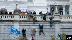 Supporters of President Donald Trump climb the west wall of the the U.S. Capitol on Wednesday, Jan. 6, 2021, in Washington.