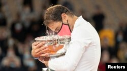 Rafael Nadal memeluk trofinya setelah laga melawan Novak Djokovic di final tunggal putra, turnamen tenis Perancis Terbuka di Roland Garros, Perancis, 11 Oktober 2020. (Foto: Susan Mullane-USA TODAY Sports)