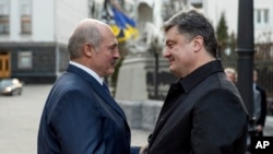 Ukrainian President Petro Poroshenko, right, welcomes Belarusian President Alexander Lukashenko during their meeting in Kyiv, Ukraine, Dec. 21, 2014.