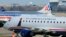 A US Airways Express plane departs from a gate past an American Airlines plane at the Ronald Reagan Washington National Airport in Arlington County, Virginia, February 10, 2013.