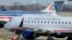 A US Airways Express plane departs from a gate past an American Airlines plane at the Ronald Reagan Washington National Airport in Arlington County, Virginia, February 10, 2013.