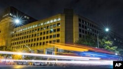 ARCHIVO - En esta foto de archivo del 1 de noviembre de 2017, el tráfico a lo largo de Pennsylvania Avenue en Washington pasa como un rayo frente al edificio de la sede de la Oficina Federal de Investigaciones.