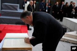 U.S. Secretary of State Mike Pompeo signs a guest book during a memorial service marking the death of 85 people who died in a 1994 bombing blamed on Hezbollah, in Buenos Aires, Argentina, Friday, July 19, 2019.