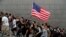 Protesters hold up their hands to symbolize five demands and a U.S. flag during a rally to the U.S. Consulate General in Hong Kong, Sept. 8, 2019.