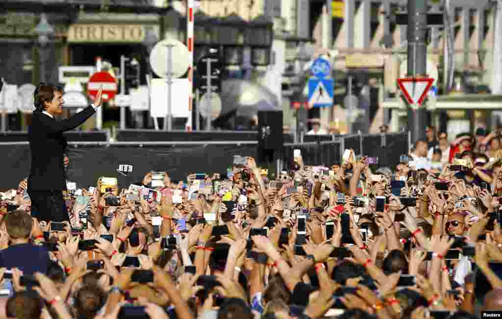 U.S. actor Tom Cruise waves to fans upon his arrival for the world premiere of Mission Impossible - Rogue Nation in front of the State Opera house in Vienna, Austria.