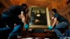 Movers prepare to hang Leonardo da Vinci's "Earlier Mona Lisa" painting ahead of its exhibition at The Arts House in Singapore, Dec. 12, 2014. 