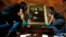 Movers prepare to hang Leonardo da Vinci's "Earlier Mona Lisa" painting ahead of its exhibition at The Arts House in Singapore, Dec. 12, 2014. 