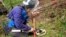 FILE - A woman practices searching for land mines during a training session involving mock land mines in El Retiro, Antioquia in Colombia, Jan. 23, 2013.
