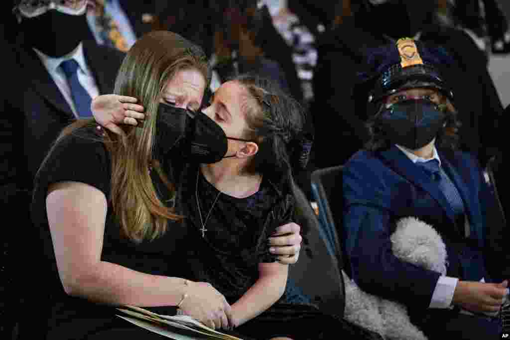 Abigail Evans, 7, and Logan Evans, 9, the children of the late Capitol Police officer William &quot;Billy&quot; Evans, sit with their mother Shannon Terranova, left, during a memorial service as Evans lies in honor in the Rotunda at the U.S. Capitol in Washington.