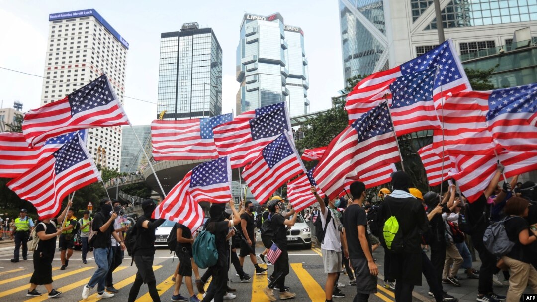 资料照：香港反送中运动期间抗议者手持美国国旗游行。（2019年9月8日）