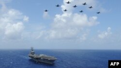 ABD Savunma Bakanlığı'nın paylaştığı fotoğrafta F/A-18C savaş uçakları USS Dwight Eisenhower uçak gemisi üzerinde uçuyor. ABD'nin iki görev gücü Ortadoğu'da konuşlandı. 