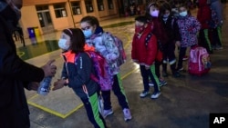 Students queue before entering the Luis Amigo school after Christmas holidays, in Pamplona, northern Spain, Jan. 10, 2022.