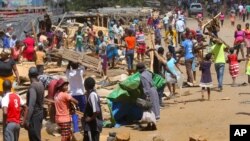 People clear destroyed stalls in the area of a popular market in a campaign to clean up the city, in Harare, Zimbabwe, April 18, 2020.