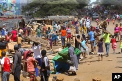 People clear destroyed stalls in the area of a popular market in a campaign to clean up the city, in Harare, Zimbabwe, April 18, 2020.