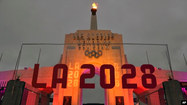 Tulisan LA 2028 terpasang di depan kaldron Olimpiade di Los Angeles Memorial Coliseum, pada 13 September 2017. (Foto: AP/Richard Vogel)