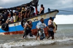 Los pescadores de Acehnesse ayudan a evacuar a los niños rohinyas de Myanmar a las costas de la aldea de Lancok, al norte de Indonesia, el 25 de junio de 2020.