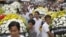 Cambodian labor union workers carry flowers as they march to mark the 7th year anniversary of Chea Vichea's death, Cambodia's former free trade union president.