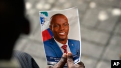 FILE - A person holds a photo of late Haitian President Jovenel Moise during his memorial ceremony in Port-au-Prince, Haiti, July 20, 2021. A federal judge in Miami on Dec. 19, 2023, sentenced former Haitian senator John Joel Joseph to life in prison for conspiring to kill Moise.