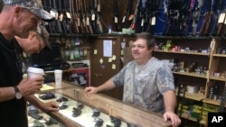 Pawn shop employee Mike Kirk talks with customers Ranny Grimmett and Joe Finfrock in Logan, West Virginia, on May 11, 2016. Kirk works for $11 an hour. It’s less than half what he made in the mines, but the best he can do these days. 