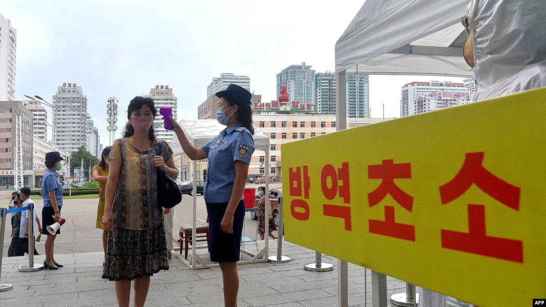 지난 2020년 8월 북한 평양역에서 신종 코로나바이러스 방역을 위해 직원이 이용객의 체온을 재고 있다.