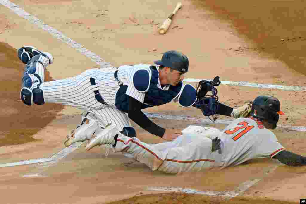 New York Yankees catcher Kyle Higashioka (66) tags Baltimore Orioles Cedric Mullins (31) out at the plate on a fielder&#39;s choice during the first inning of a baseball game, April 6, 2021, at Yankee Stadium in New York.